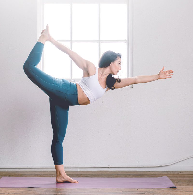 Yoga instructor posing on one leg